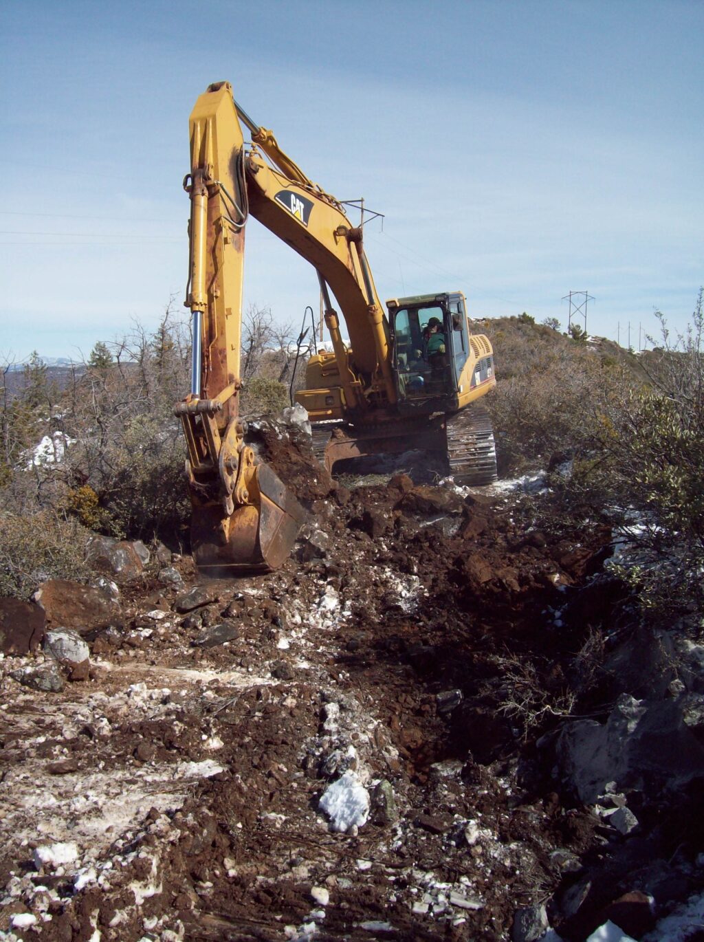 Backhoe digging in frozen ground