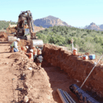 Construction crew digging a ditch with a backhoe