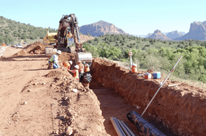 Construction crew digging a ditch with a backhoe