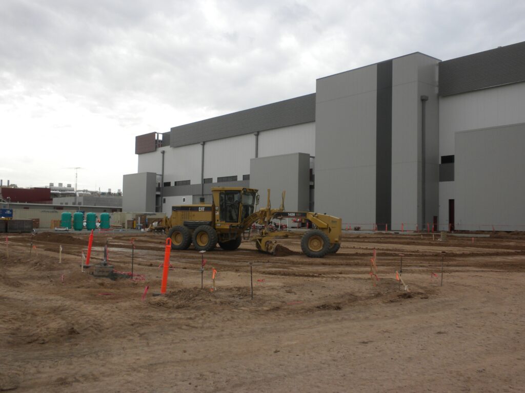 Earth mover clearing an area next to a building