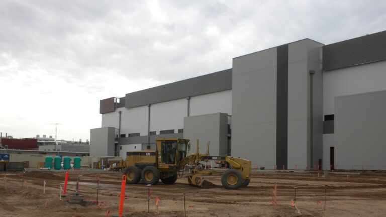 Earth mover clearing an area next to a building