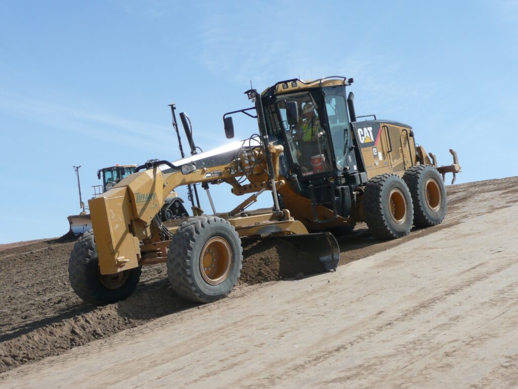 Earth mover grading a slope