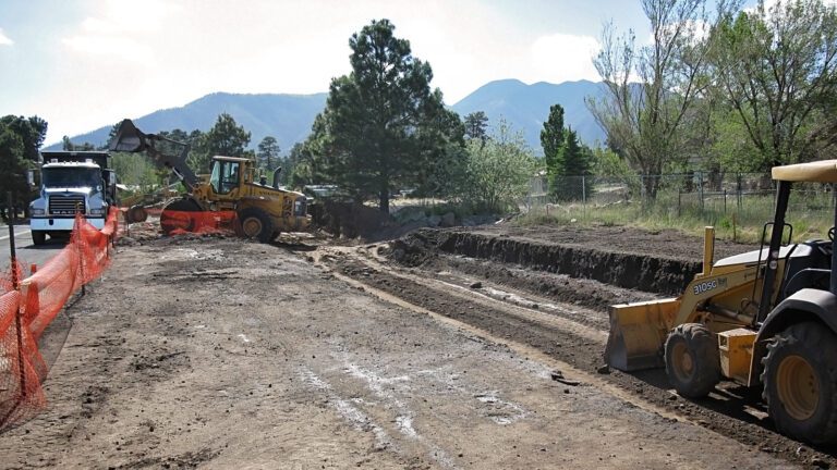 Front loader filling a truck with dirt