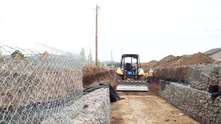Front loader in a partially completed rock lined drainage channel