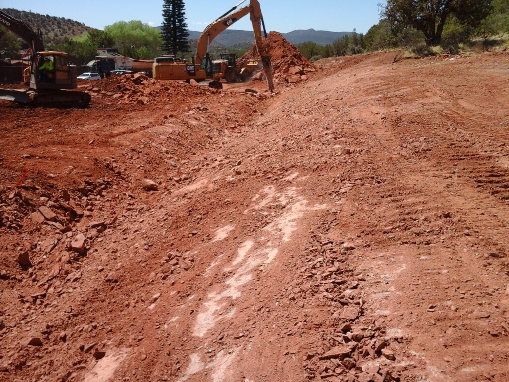 Machine breaking rocks at the bottom of a graded slope