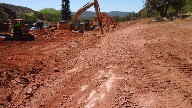 Machine breaking rocks at the bottom of a graded slope