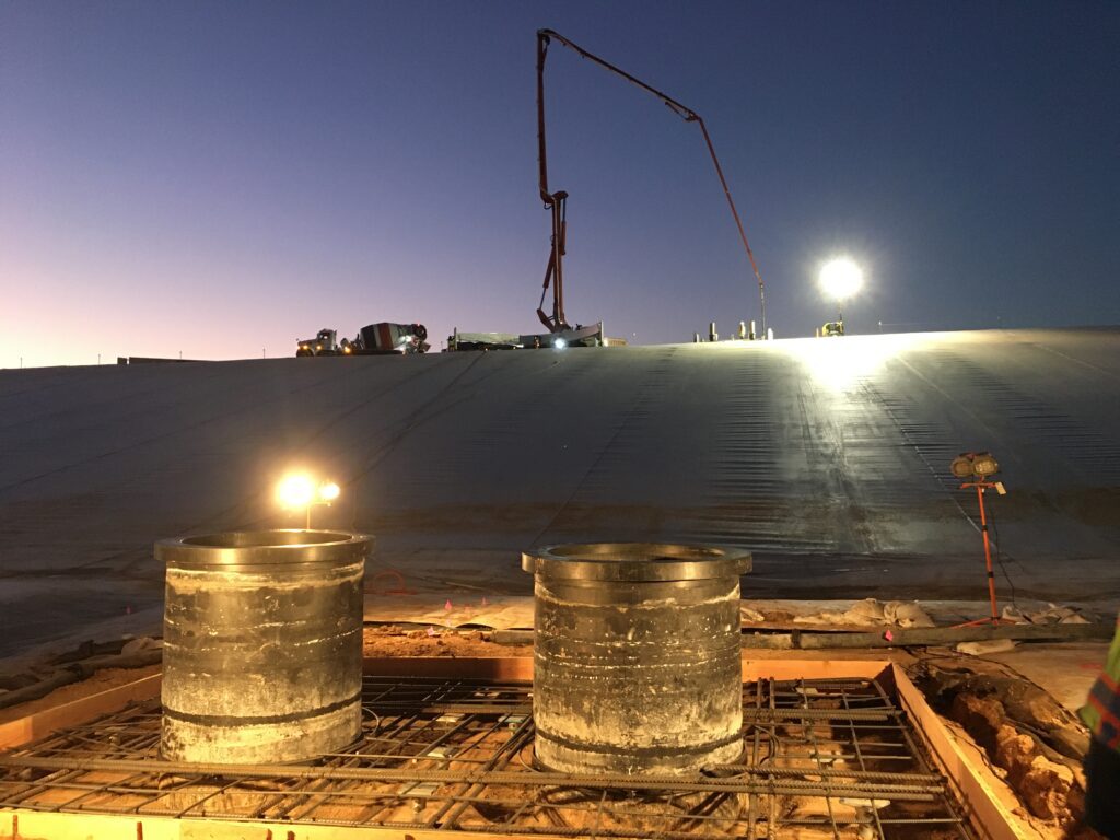 Nighttime construction with lights and a large crane