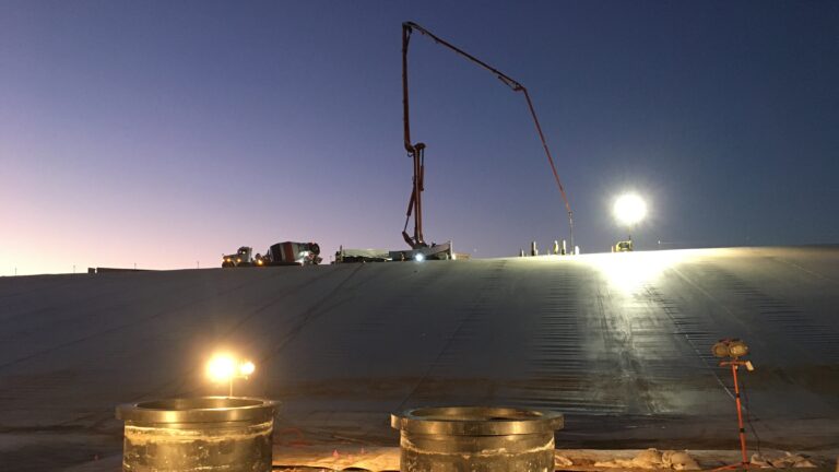 Nighttime construction with lights and a large crane